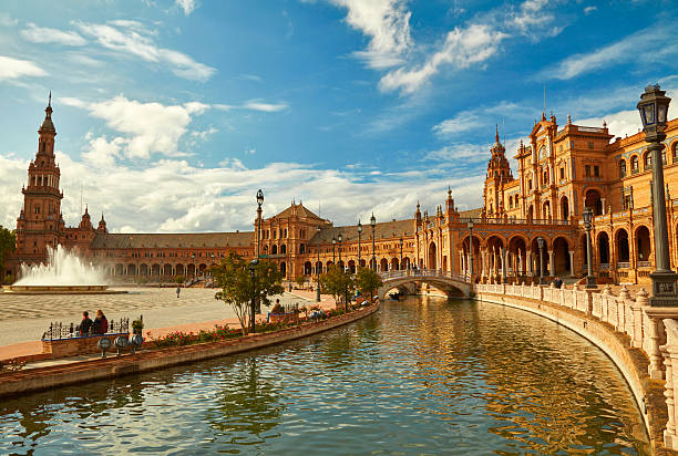 Plaza de España in Seville with canal, bridges, and ornate architecture at golden hour