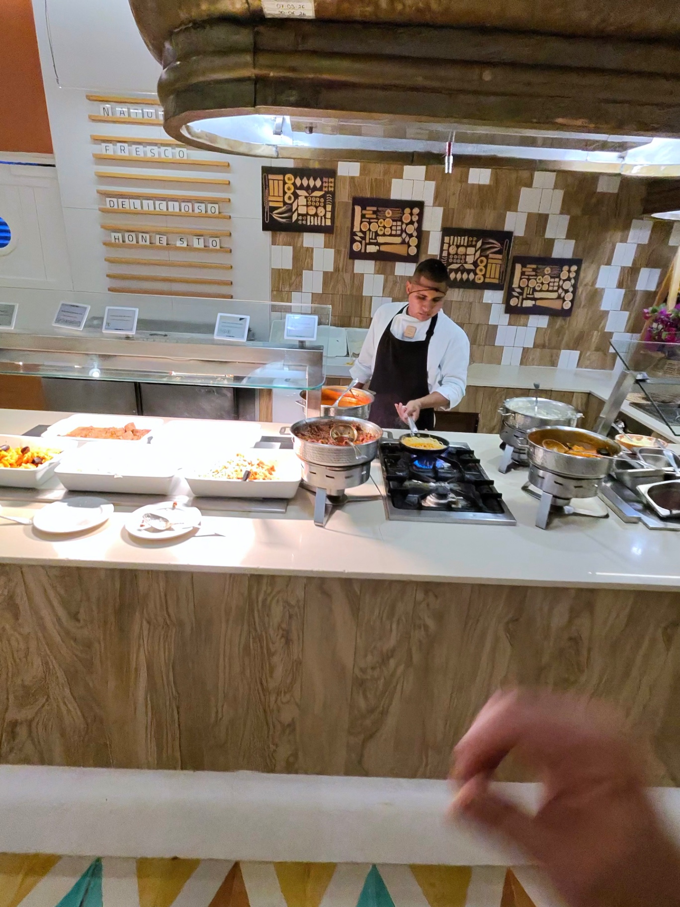 Chef preparing hot dishes at live cooking station